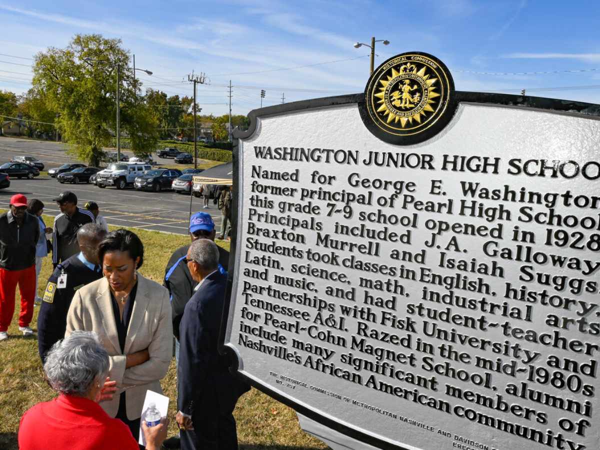 AD Candice Storey Lee stands next to the Washington Junior High School marker
